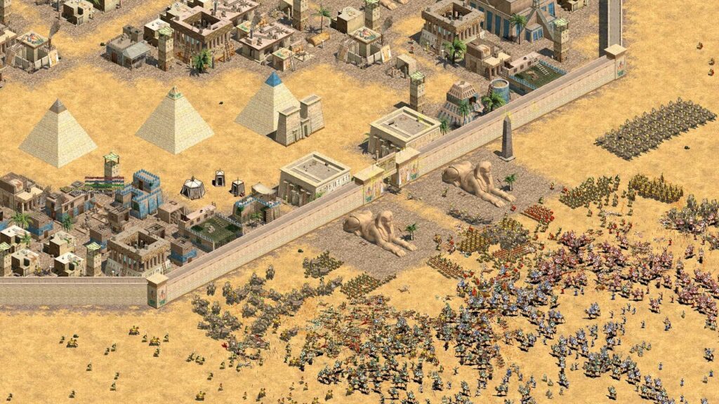Classic Age of Empires II gameplay screenshot showing a massive desert battle near Egyptian pyramids and a fortified city